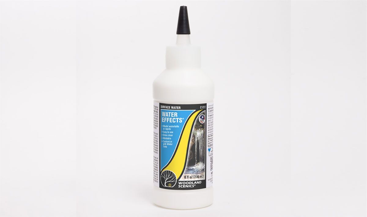 White bottle with black nozzle and colorful label on a plain white background