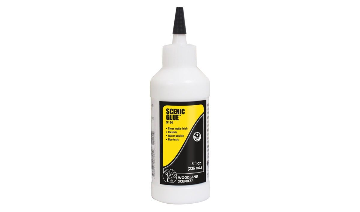 White squeeze bottle with black nozzle and yellow-and-black label on a plain background