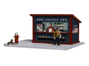 Small newsstand labeled “FAKE NEWS” with a man reading a screen and a person sitting nearby; a fire hydrant stands beside it.