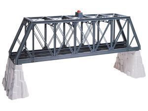 Gray steel truss bridge spanning two rock supports, with a small red object on top.