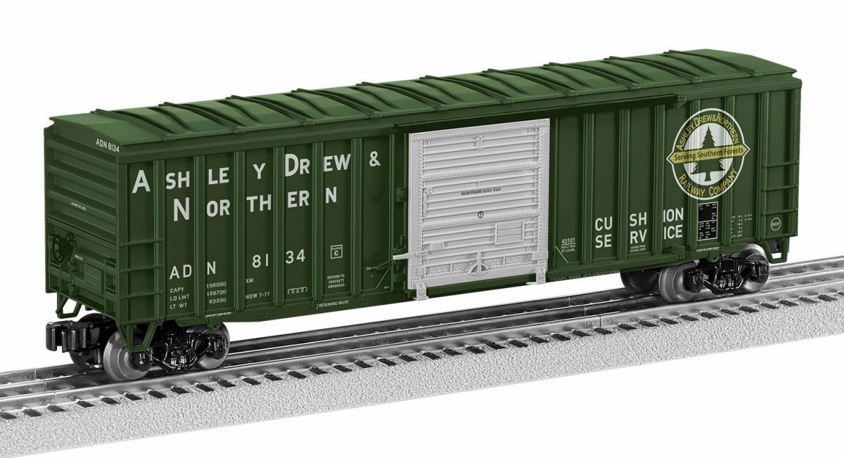 Green boxcar model train with white lettering on tracks