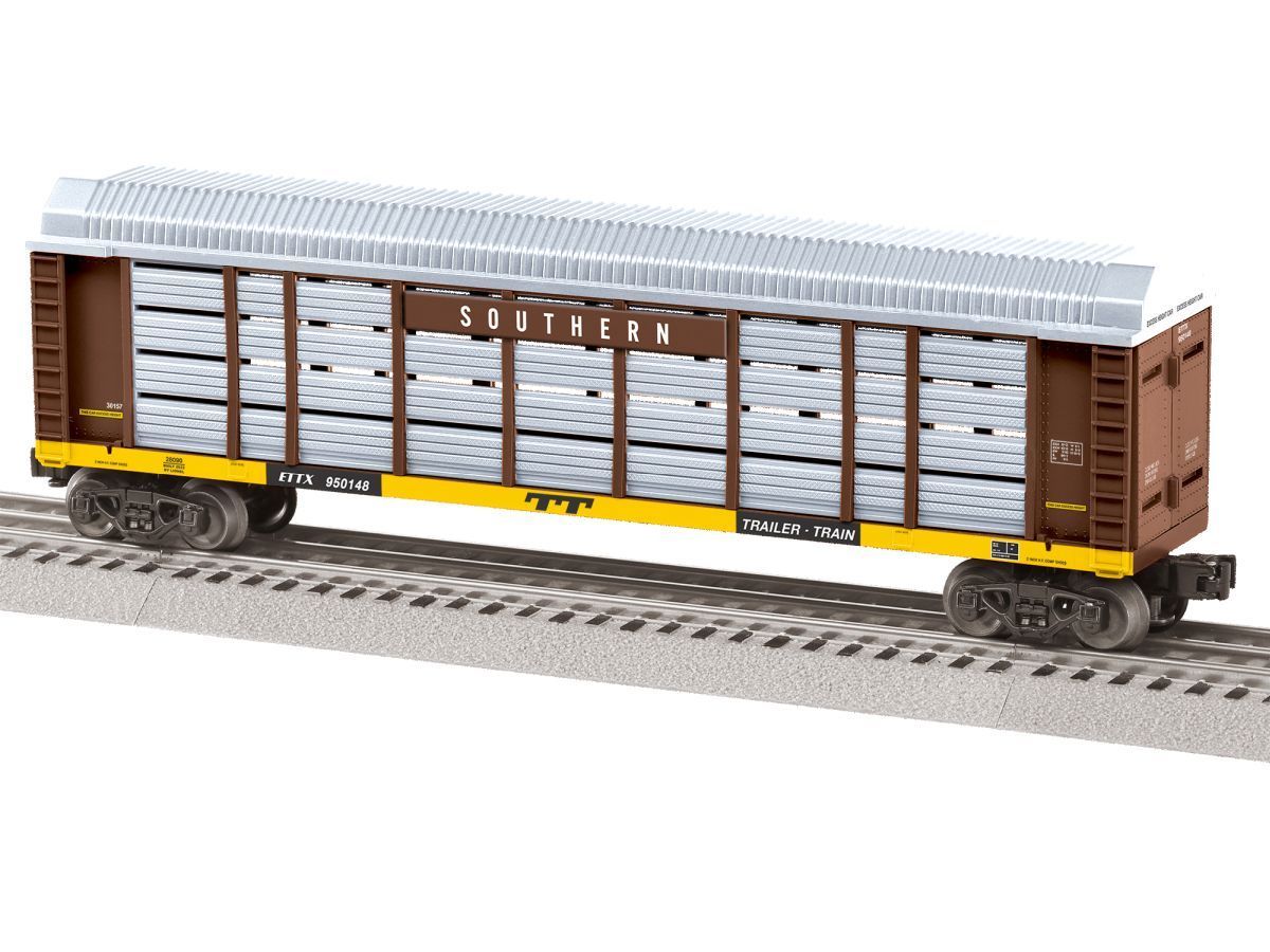 Brown and yellow freight train car on tracks, labeled “FOREST,” with logs inside