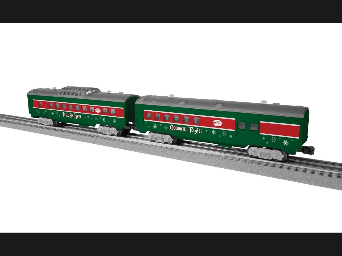 Green model train cars on railroad track, with red window panels and silver wheels.