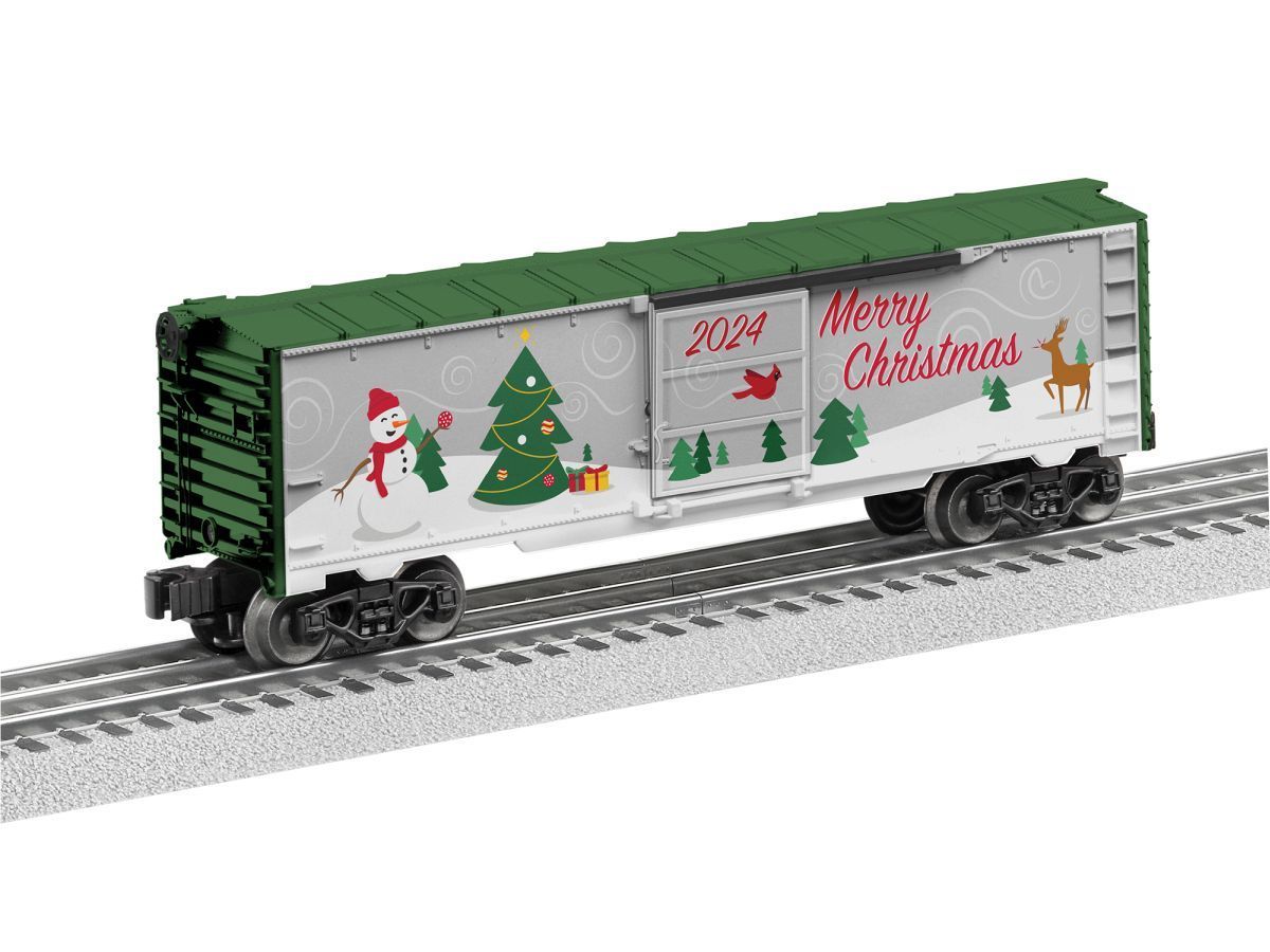Green Christmas-themed train car with snowman, tree, and “Merry Christmas” decorations on tracks