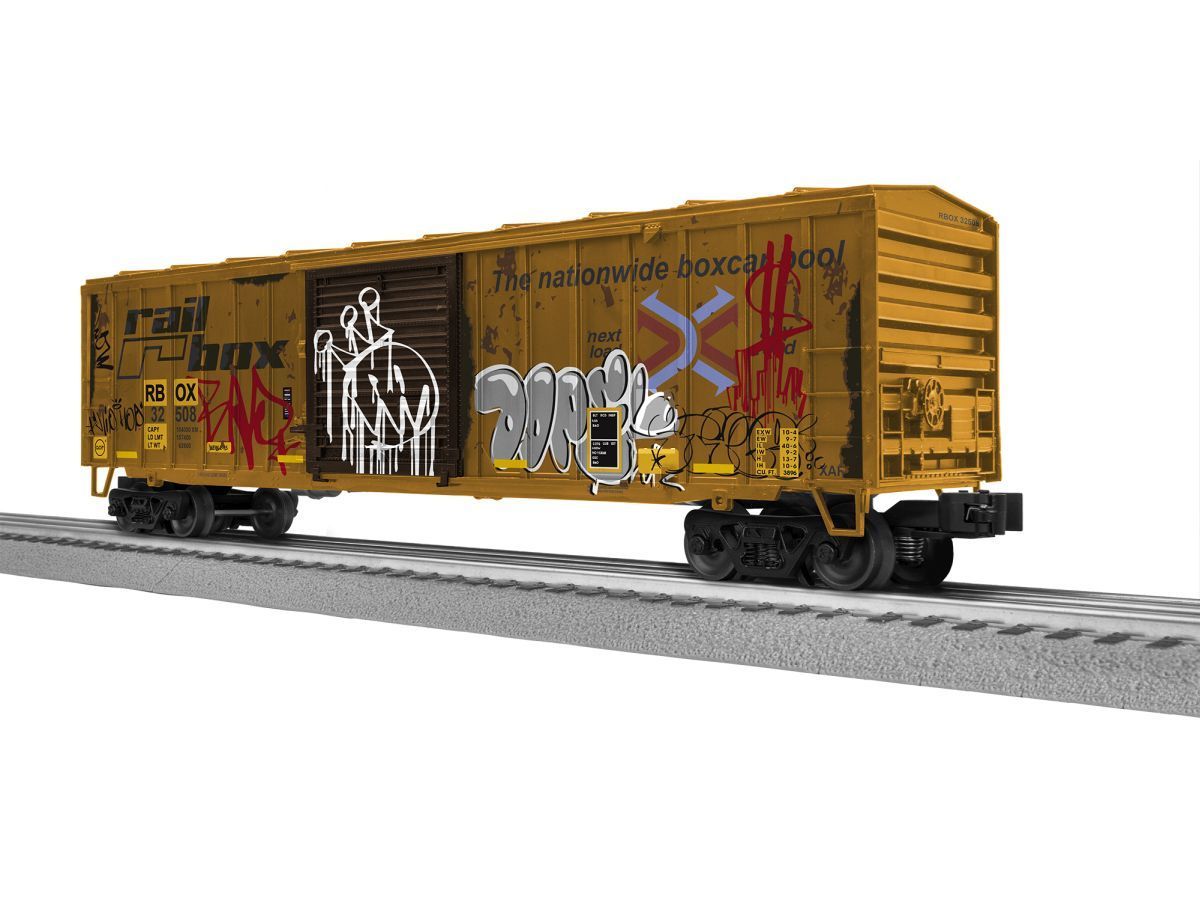 Yellow graffiti-covered boxcar on railroad tracks, side view.