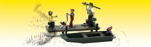 People on a green boat in a marshy field, one holding a fishing rod under a yellow sky