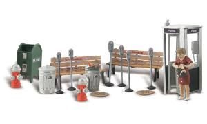 Miniature of a railroad crossing with gates, signs, trash cans, and a person at a phone booth