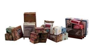 Assorted vintage suitcases and boxes stacked in a row, in muted brown and red tones