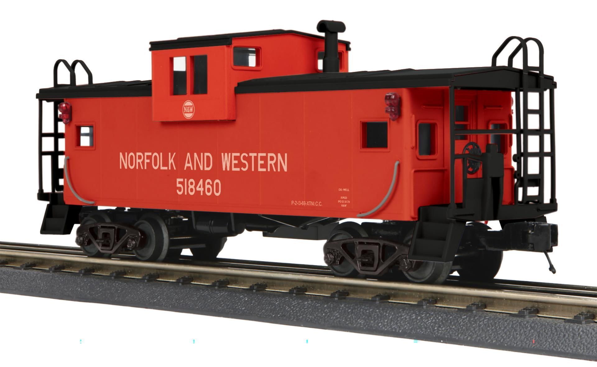 Red Norfolk and Western caboose on railroad tracks, side view