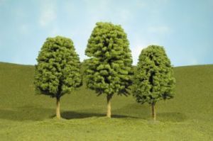 Three green trees on a grassy hill under a blue sky