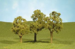 Three small trees on a grassy hill under a blue sky