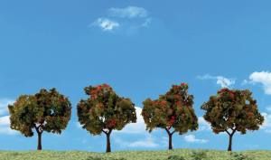 Four autumn trees on a grassy hill beneath a bright blue sky