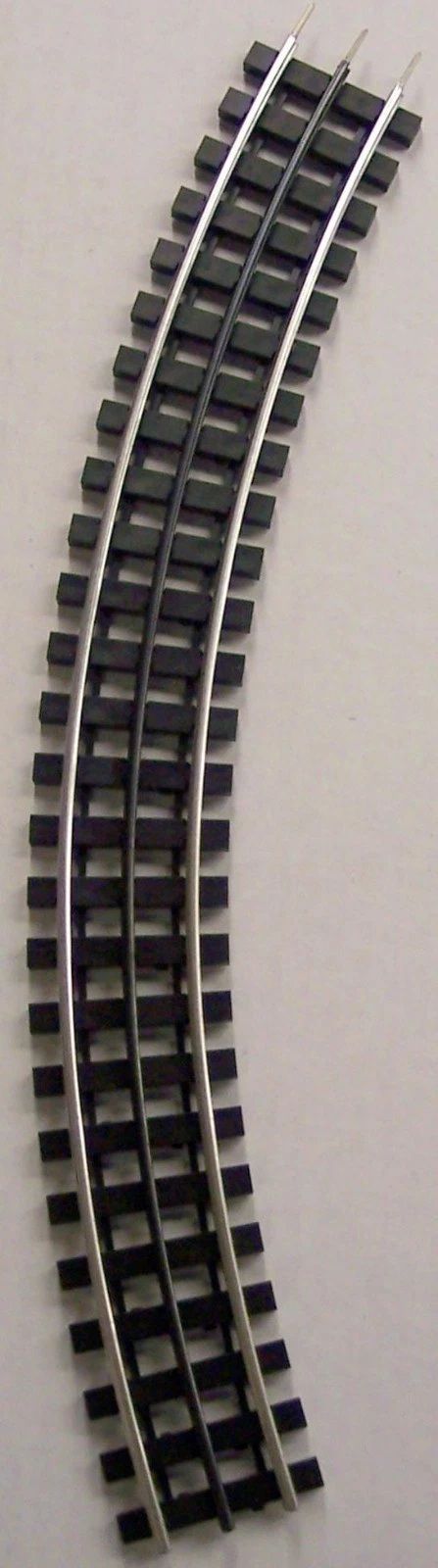 Curved black-and-gray segmented track pieces arranged in parallel lines on a white background