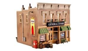 Miniature general store model with tan brick facade, green awning, and “GENERAL STORE” sign.