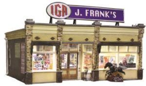 Small vintage IGA grocery store with a purple J. Frank’s sign and lit storefront windows