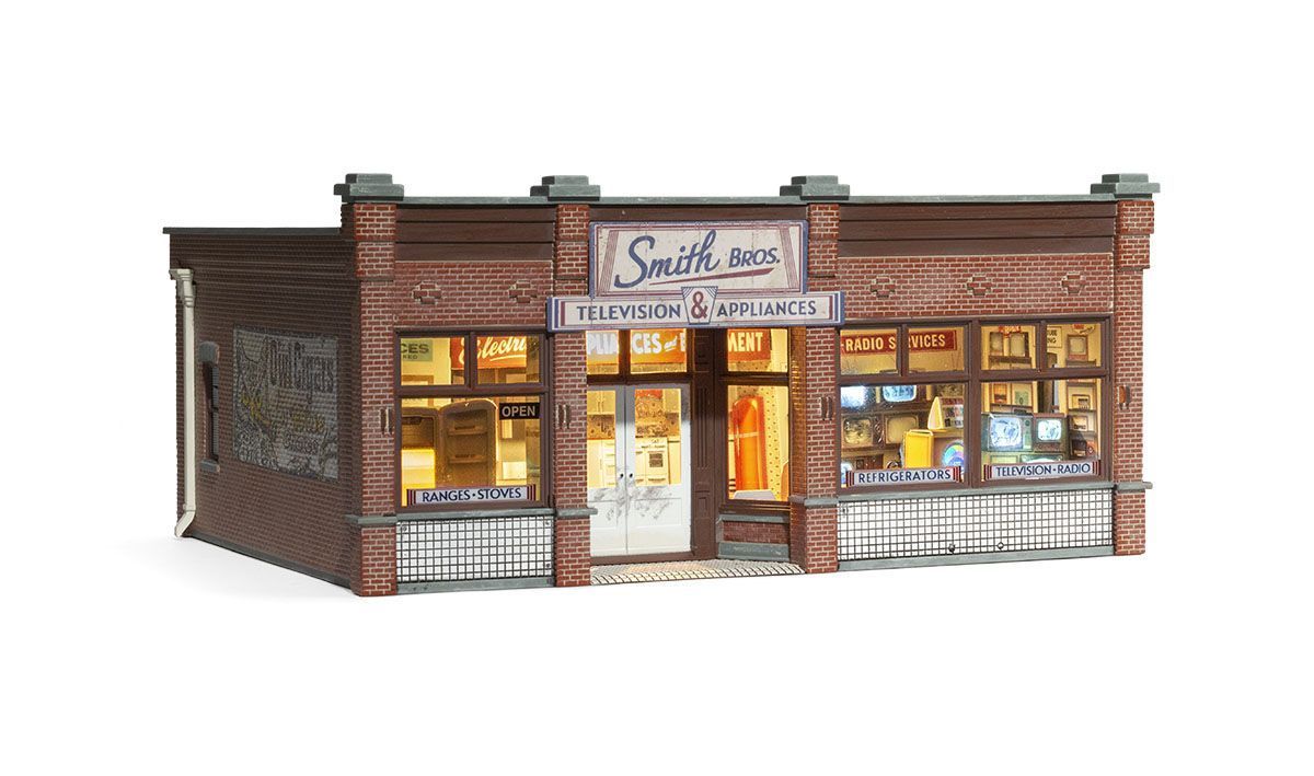 Brick storefront with lit windows and a sign reading “Smith’s” at dusk