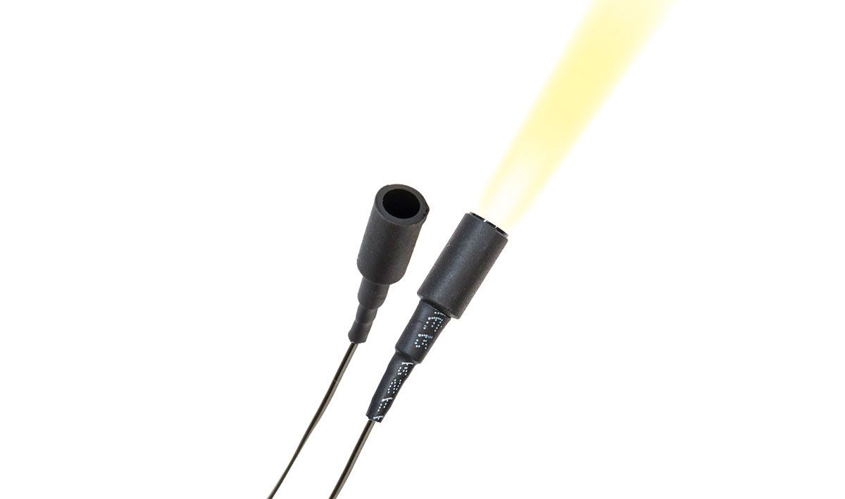 Two black wired stage microphones with a yellow light beam in the background