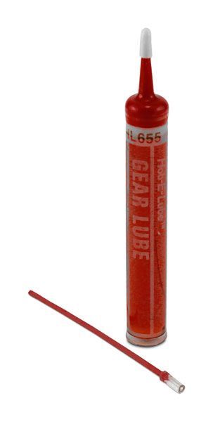 Red glue tube with white nozzle and cap lying beside it on a white background