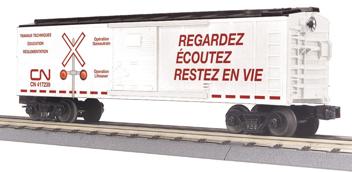 White CN freight boxcar on tracks with red French safety text: “REGARDEZ ÉCOUTEZ RESTEZ EN VIE”