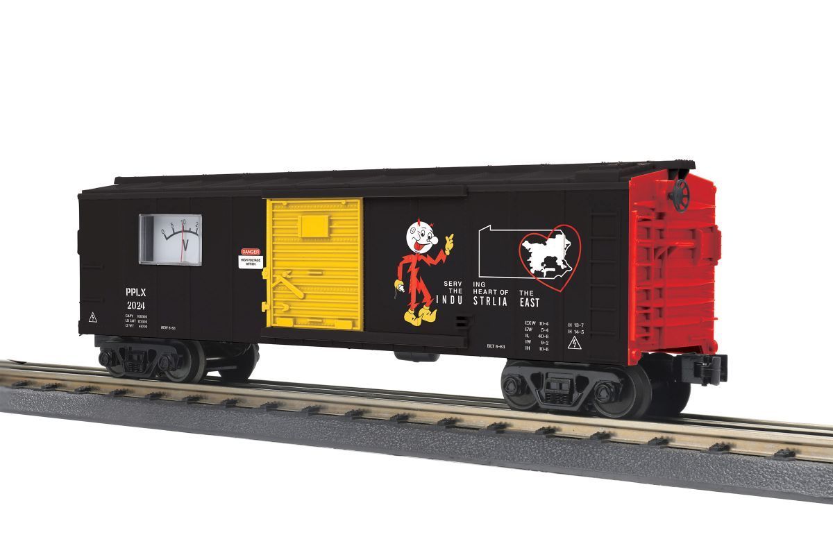 Black freight boxcar with yellow doors and colorful graffiti on train tracks