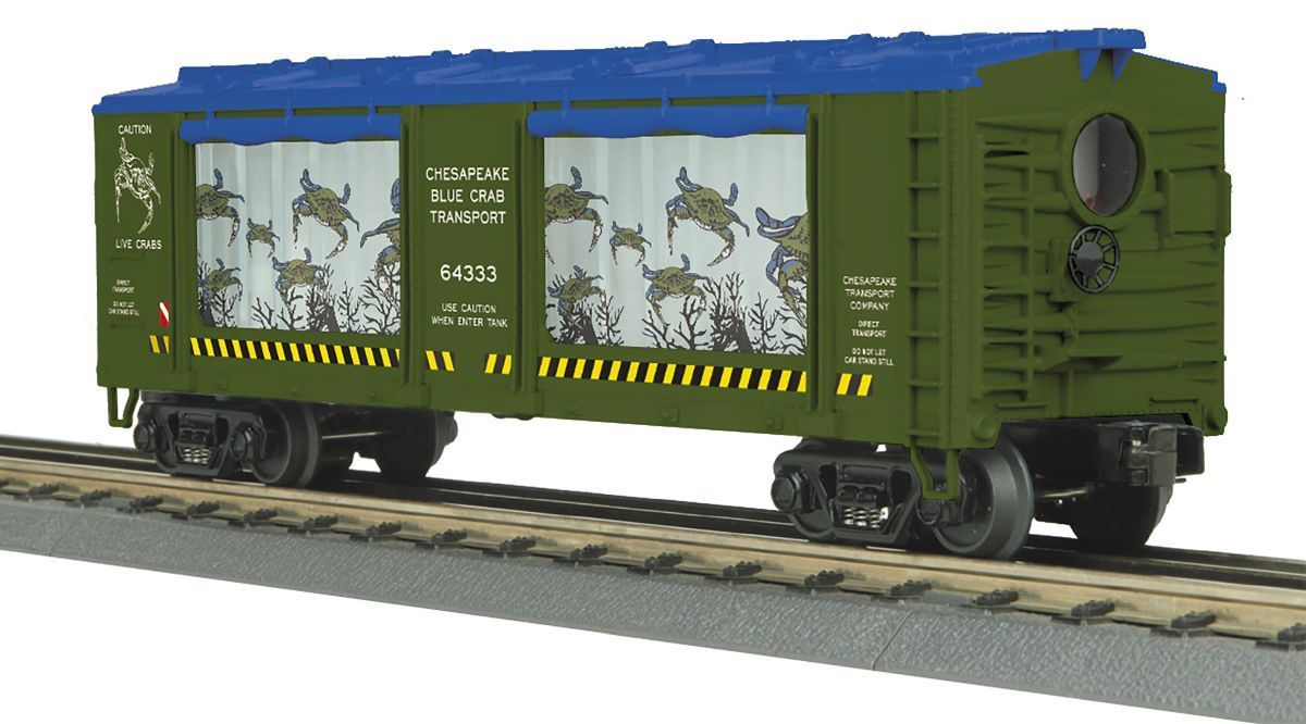 Green freight train car with blue roof and white doors on tracks