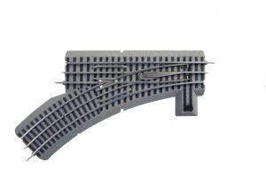 Gray toy train track switch with curved and straight rails on a white background