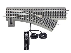 Model railroad track switch with controller and wiring, silver rails on gray base.