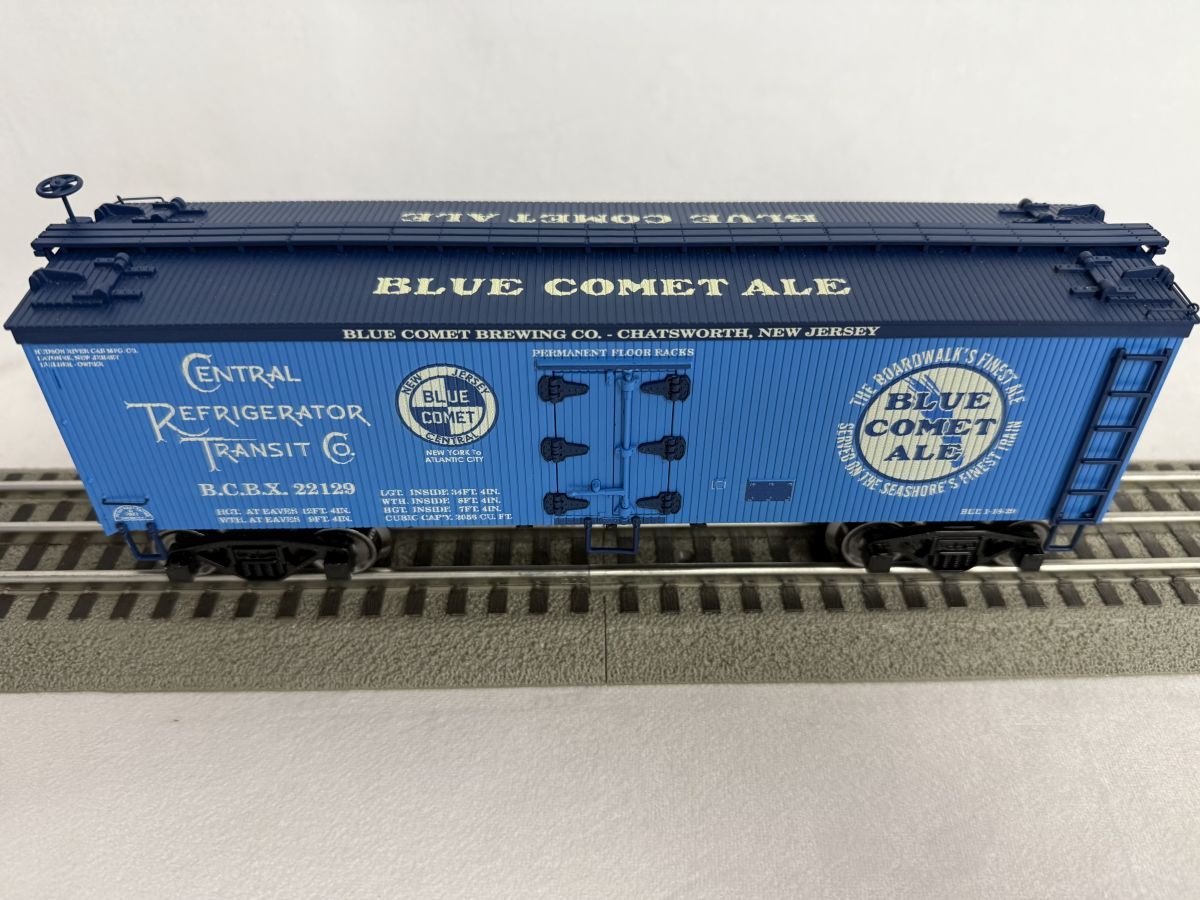 Blue rail boxcar model labeled “BLUE COMET ALL” on train tracks, in bright blue with white logos.