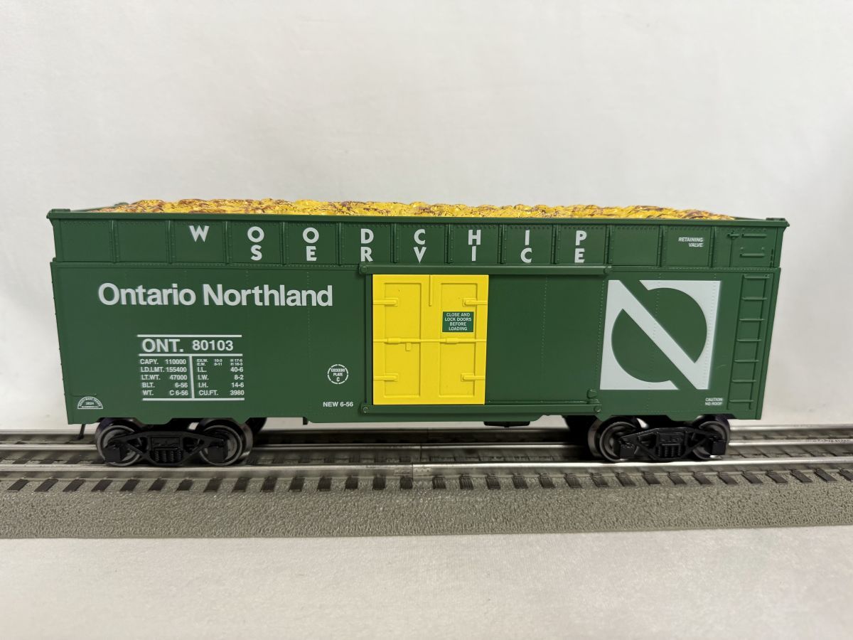 Green Ontario Northland boxcar with yellow doors on model train tracks