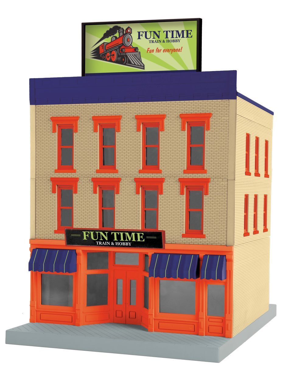 Miniature storefront building with orange trim and blue awnings, topped by a green “FUN TIME” sign.