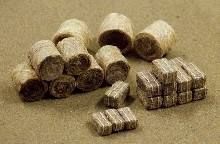 Bundles of rolled and stacked banknotes on a tan surface