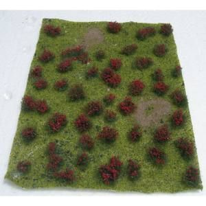 Small square grassy model with scattered red shrubs and a few bare patches