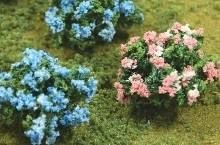 Blue and pink flowering shrubs in a green garden bed