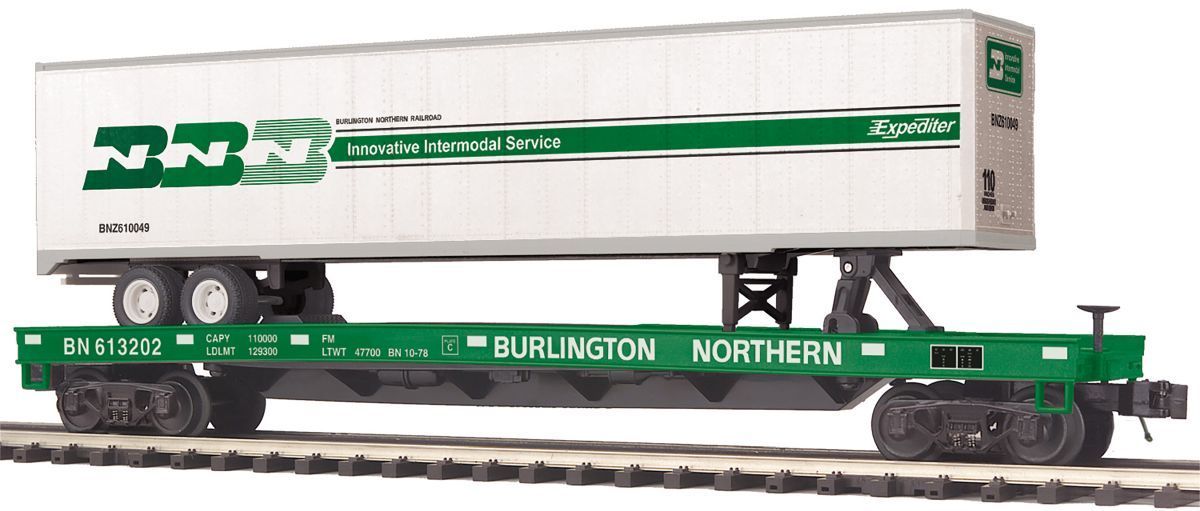 Green Burlington Northern model train hauling a white trailer on a flatbed railcar