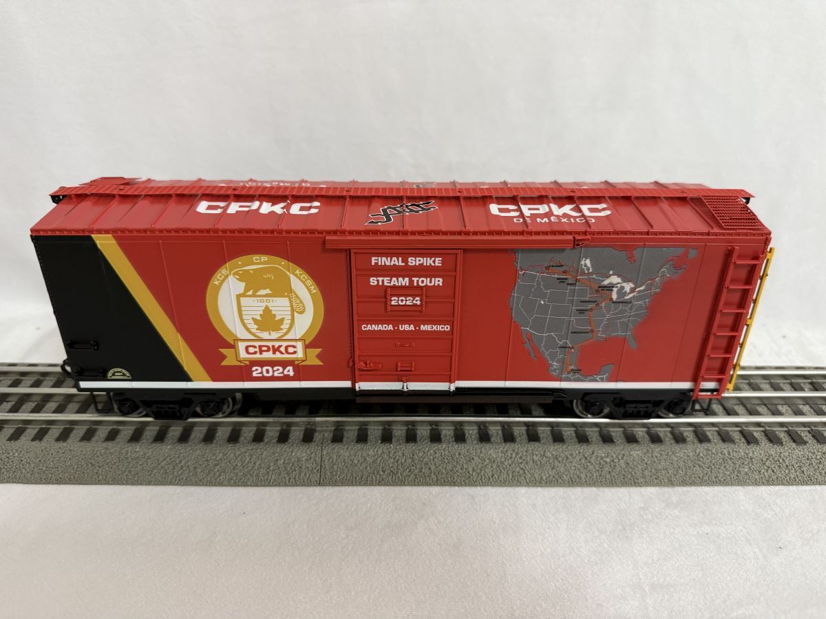 Red model boxcar on tracks with gold CHIHSO 2024 emblem and map graphics