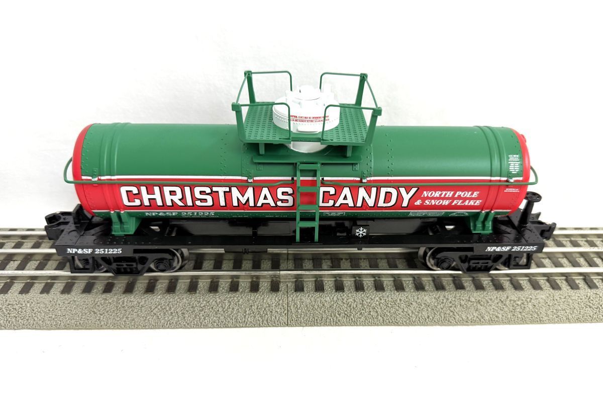 Green tanker railcar labeled “CHRISTMAS CANDY” on train tracks
