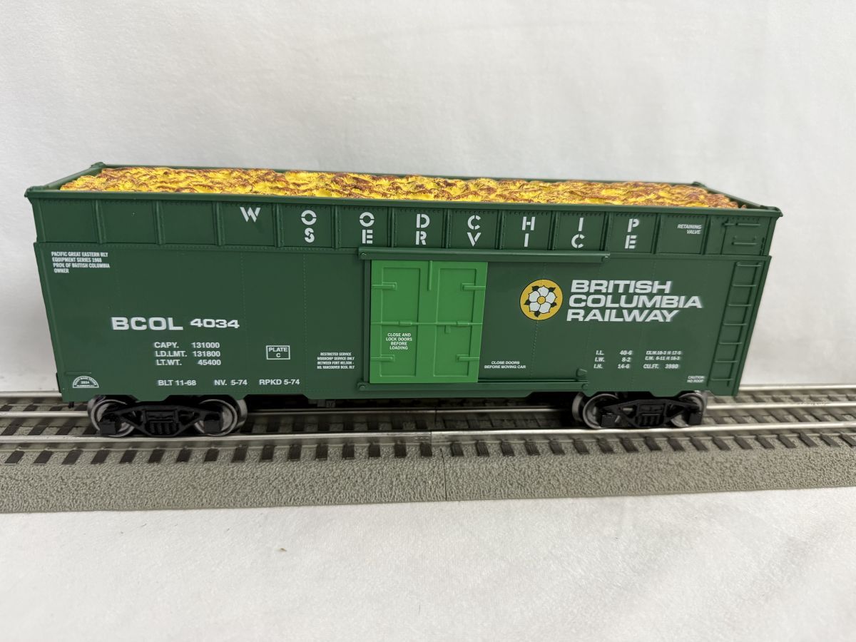 Green British Railways boxcar model on train tracks, with yellow roof and central doors