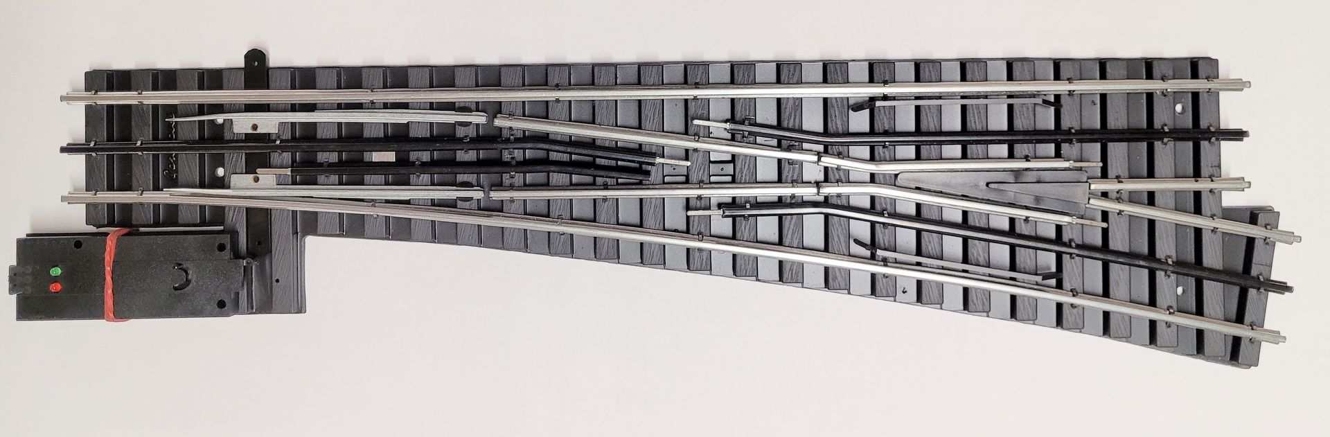 Curved model train track layout with multiple parallel rails and switches on a white background