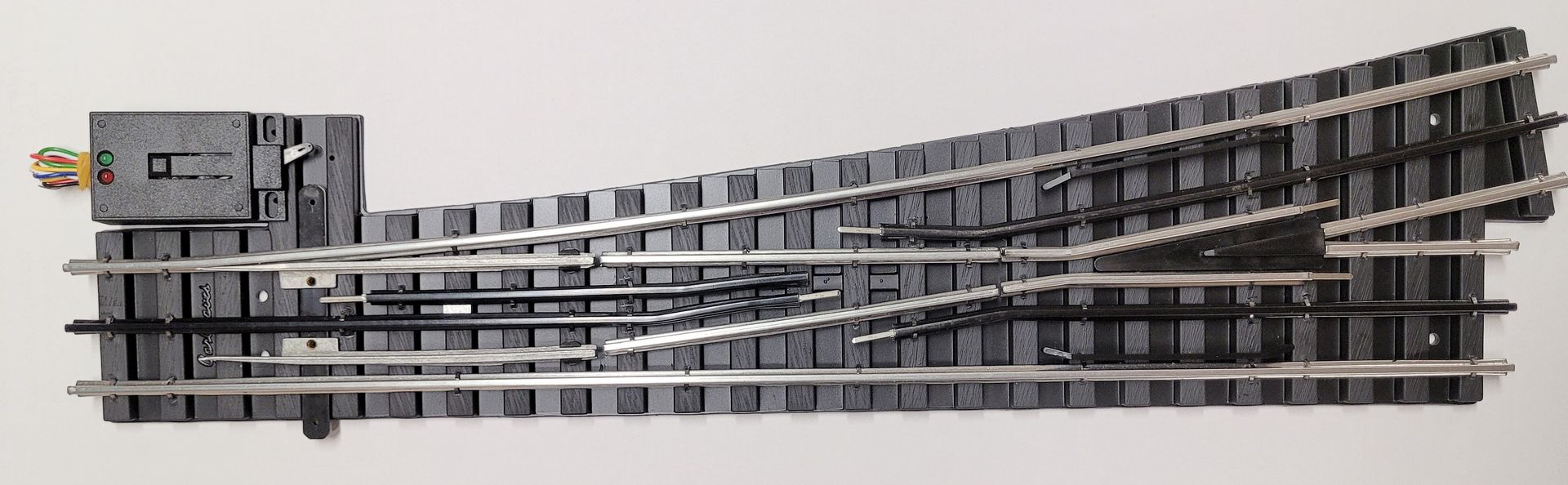 Gray model railroad turnout switch track on a white background