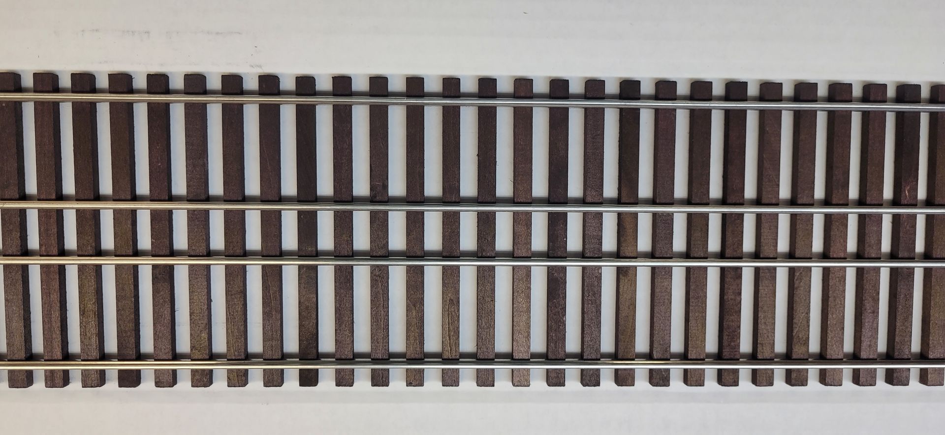 Railroad tracks viewed from above, showing two parallel rails with dark wooden ties.