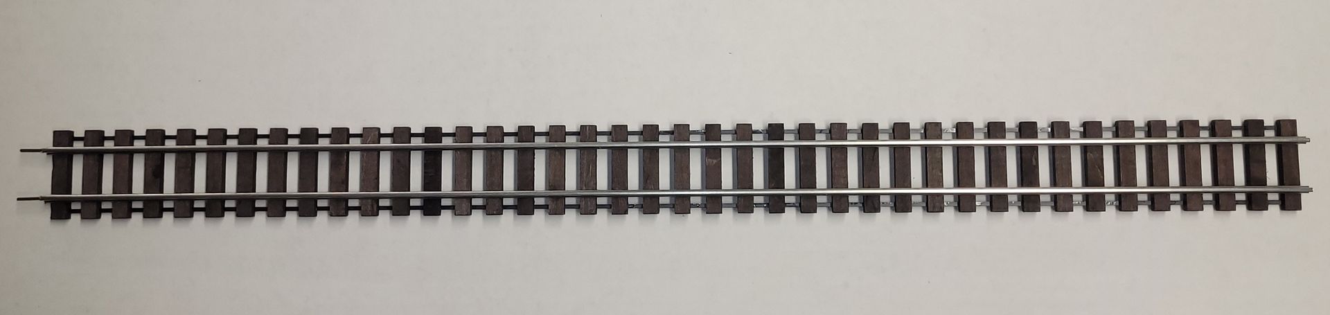 Long straight railroad track on a white background