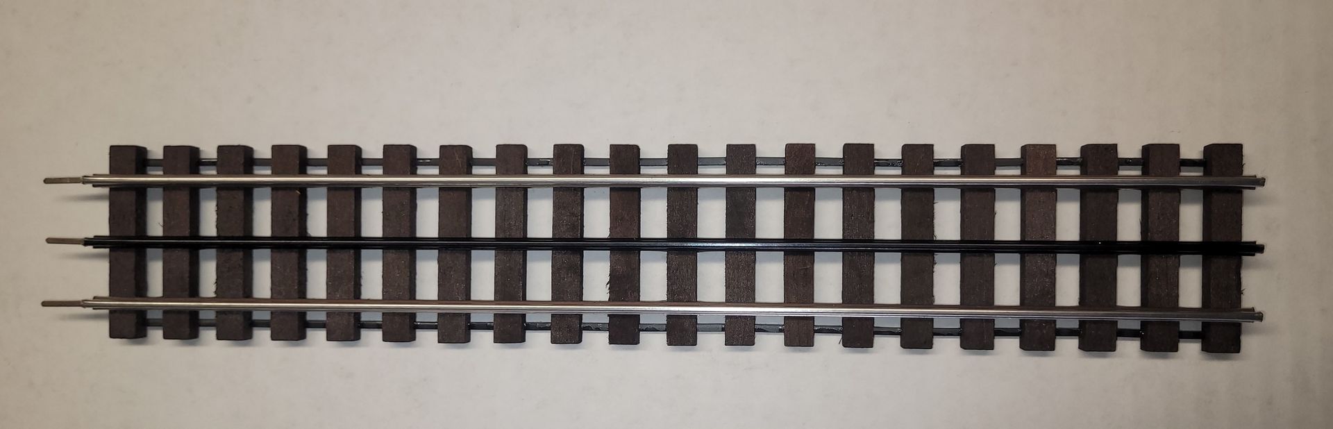 A short section of model railroad track on a light background.