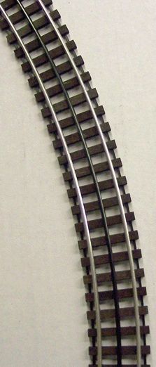 Curving model train track on a light background