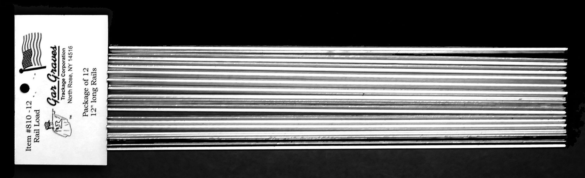 A white label attached to a bundle of long, thin silver wires on a black background.
