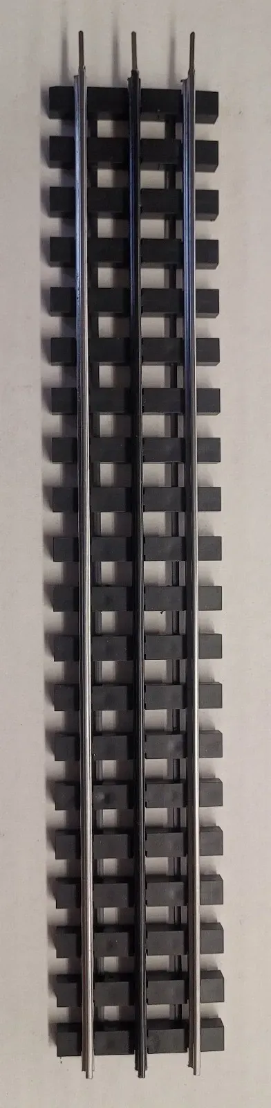 Vertical metal rail track with evenly spaced black connectors on a light background