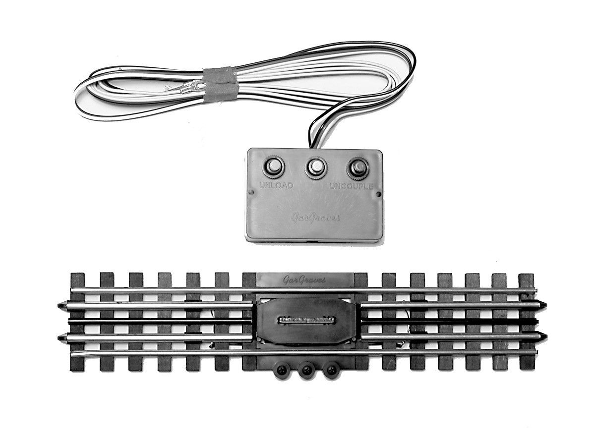 Train track accessory kit with silver wire, control box, and black rails on a white background