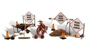 Construction cones and barricades around holes with signs reading “Road Work Ahead”