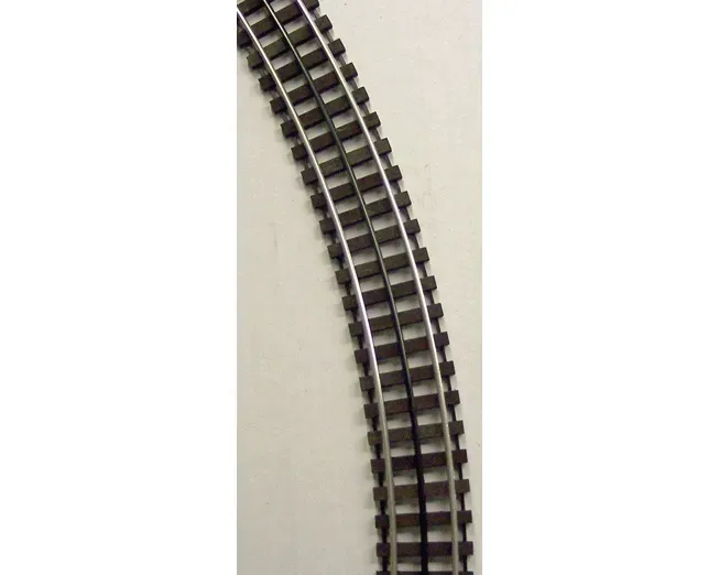Curved section of a miniature model train track on a light background