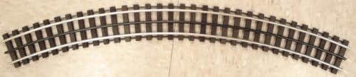 Curved section of model train track on a beige surface
