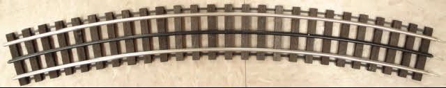 Curved model train track section on a white background